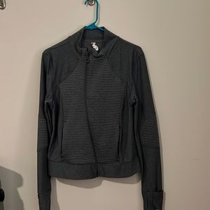Grey Women’s athletic jacket with asymmetrical zipper.